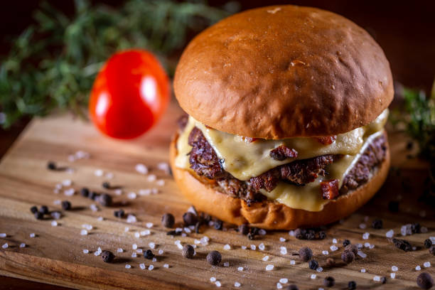 istock Craft beef smash burger with cheese, bacon and sauce on wooden background 1304061892