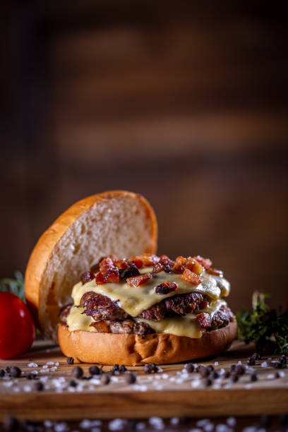 istock Craft beef smash burger with cheese, bacon and sauce on wooden background 1304061952
