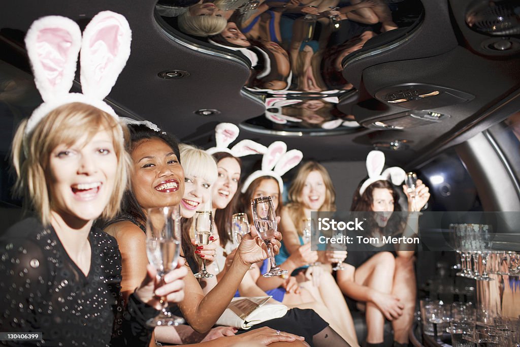 Las mujeres en las orejas de conejo brindis en dorso de limusina - Foto de stock de Champán libre de derechos