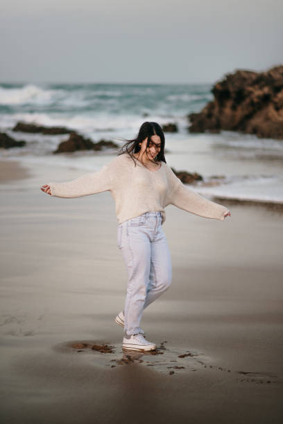 istock Cheerful young woman having fun at beach 1304064650
