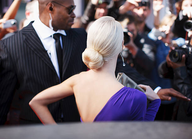 Celebrity emerging from car towards paparazzi  black man blonde hair stock pictures, royalty-free photos & images