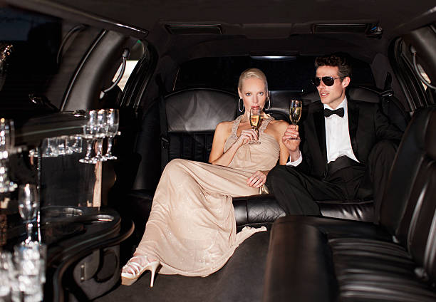 pareja bebiendo champán en limusina - evening gown fotografías e imágenes de stock