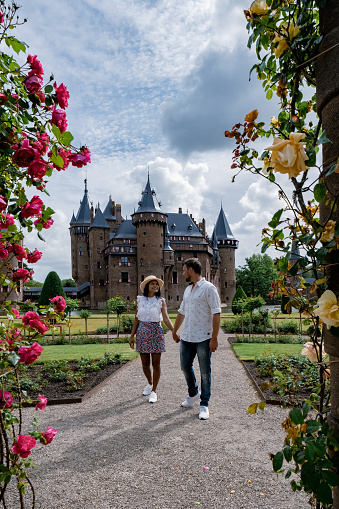Castle de Haar Utrecht, couple men and woman mid age European and Asian visit De Haar Castle in Dutch Kasteel de Haar is located in Utrecht Netherlands during Spring with flowers in the garden