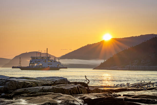istock Ferry passing across Saguenay river in Tadoussac during sunset with a nice low cloud in foreground 1304068568