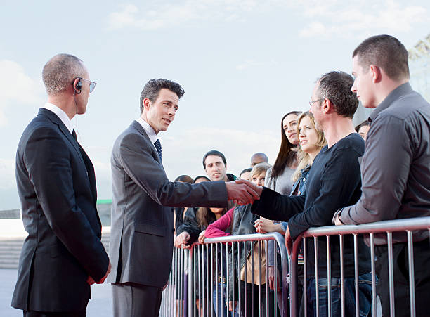 Politician shaking hands with people behind barrier  red carpet event photos stock pictures, royalty-free photos & images