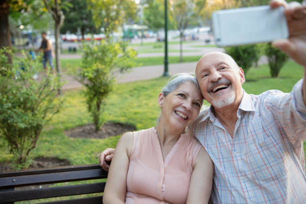 istock Senior couple having fun outside and taking selfies 1304069324