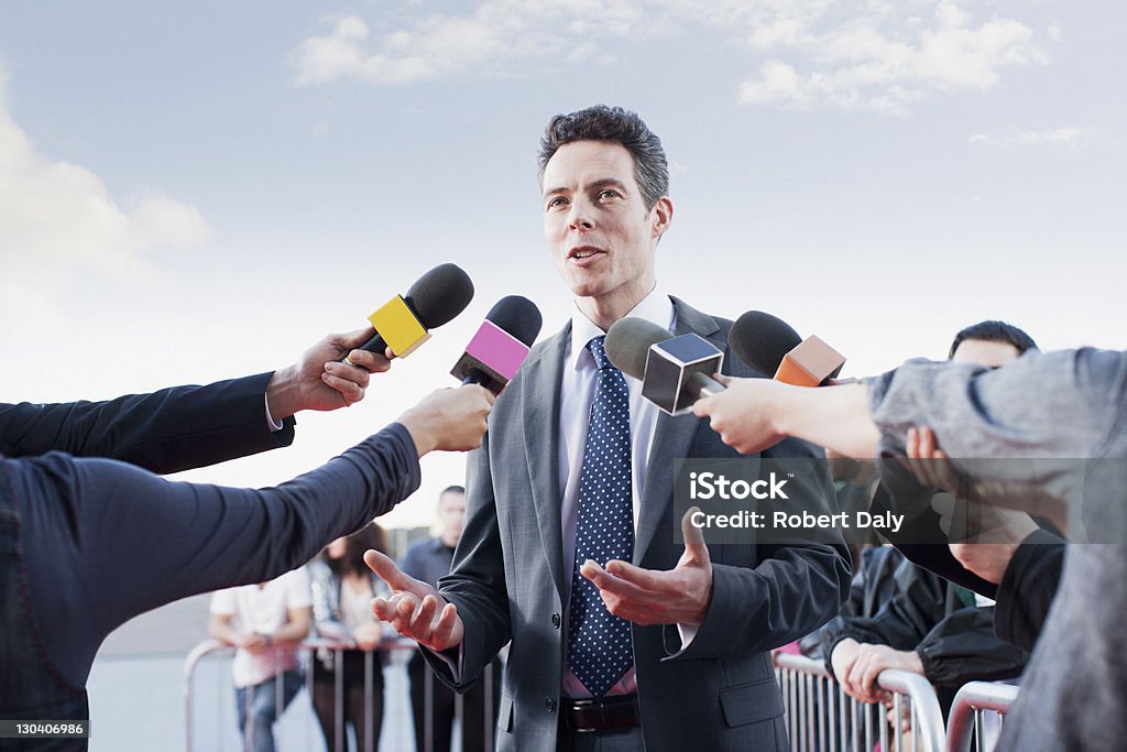 Politician talking into reporters' microphones  Politician Stock Photo