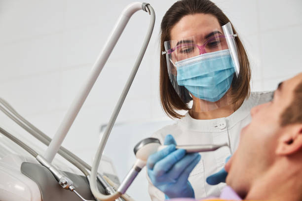 macho con abridor de boca recibiendo dientes operados con pieza de mano - handpiece fotografías e imágenes de stock