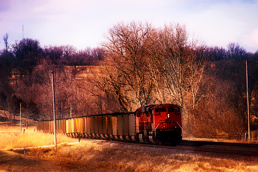 A photo illustration of a locamotive pulling a line of freight cars along a stretch of rural railroad track in Missouri. The original image which this illustration is based on was captured on Feb. 24, 2021, just south of Clarksdale, Missouri, USA.