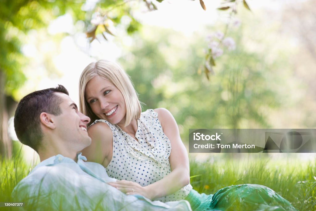 Couple sur herbe ensemble de l'établissement - Photo de Femmes libre de droits