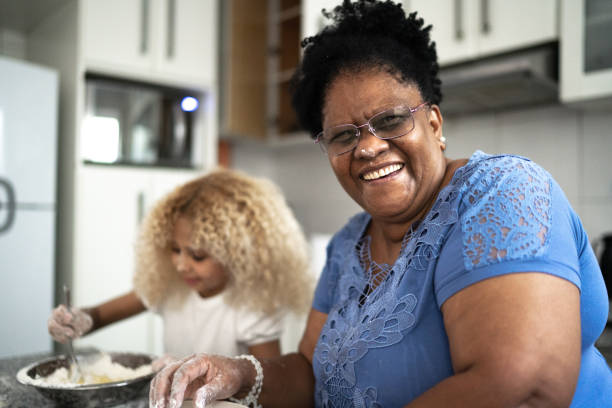 porträt der großmutter backt mit enkelin zu hause - grandmother cooking baking family stock-fotos und bilder