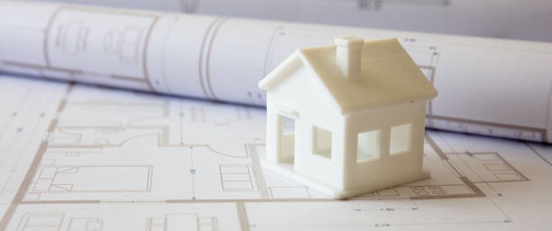 istock Construction concept. Residential building drawings and architectural house model on an office desk 1304074024