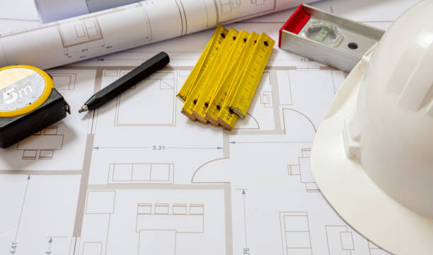 istock Construction concept. Residential building drawings and hardhat on an office desk 1304074078