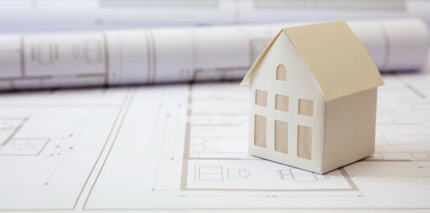 istock Construction concept. Residential building drawings and architectural house model on an office desk 1304074086