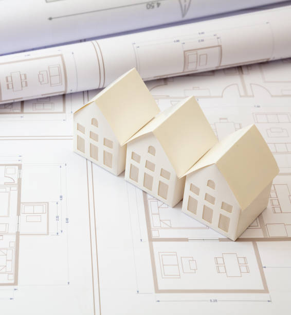 istock Construction concept. Residential building drawings and architectural house models on an office desk 1304074094