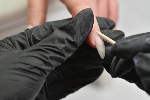 istock Lifting the cuticle with an orange stick, before the combined manicure 1304075686
