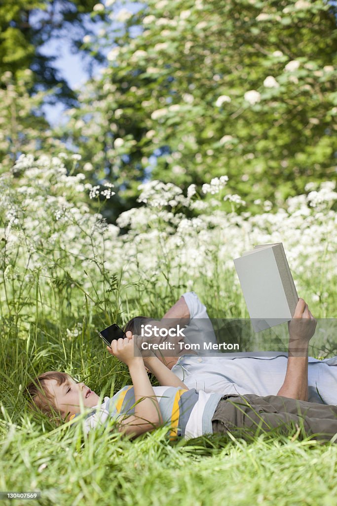 Padre e figlio rilassante in erba - Foto stock royalty-free di 30-34 anni