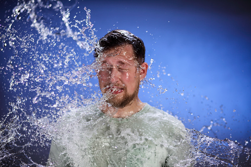 Hombre siendo salpicado con agua photo