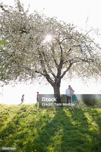 Family Playing Under Tree Outdoors Stock Photo - Download Image Now - Springtime, Daughter, Day