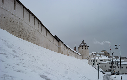 Winter view of the watchtower and the fortress wall of the Kazan Kremlin. Snowfall. Romantic photo. Kazan, Tatarstan, Russia.