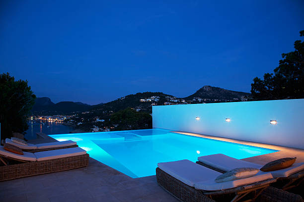 бассейн с шезлонгами на ночь - swimming pool infinity pool patio sea стоковые фото и изображения