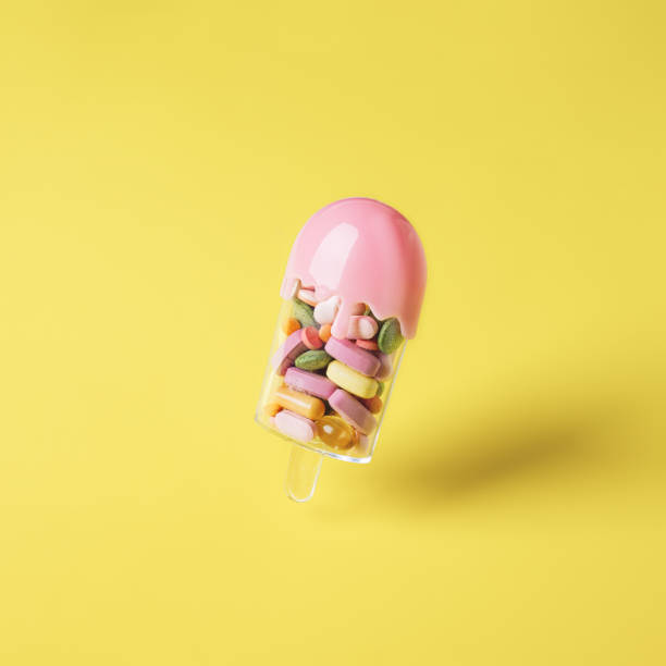 istock Creative layout with popsicle ice cream filled with various pills and tablets on bright yellow background 1304079615