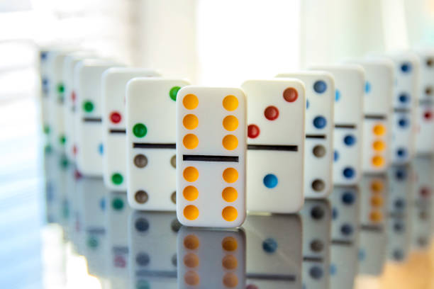 istock white dominoes stand in row on mirror surface with double six leading the way 1304080746