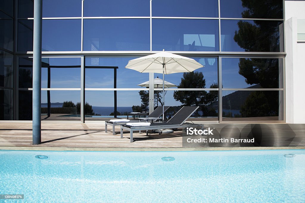 Lounge chairs and umbrella beside pool  Color Image Stock Photo