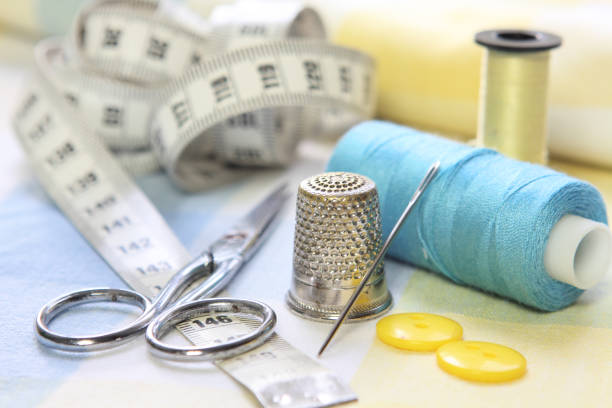 istock sewing accessories with blue and yellow threads, tape measure and scissors on fabric background 1304081826