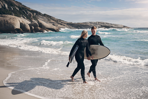 Shot of a young couple out surfing together at the beach