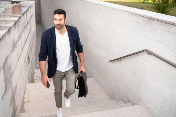 istock Modern young businessman moving upstairs on his way to work 1304083847