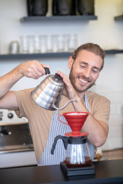 istock Smiling man pouring water into a pourover 1304083964