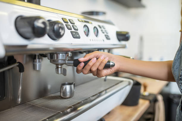 istock Womans hand holding holder of coffee machine 1304084127