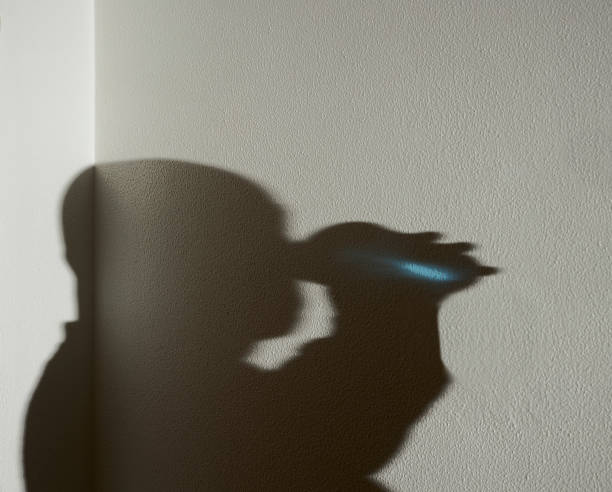 istock Shadow of a man drinking from a glass on a white wall 1304084770