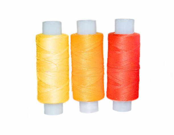 istock Yellow, orange and red sewing threads on a white background. Close-up. Isolated. 1304085041