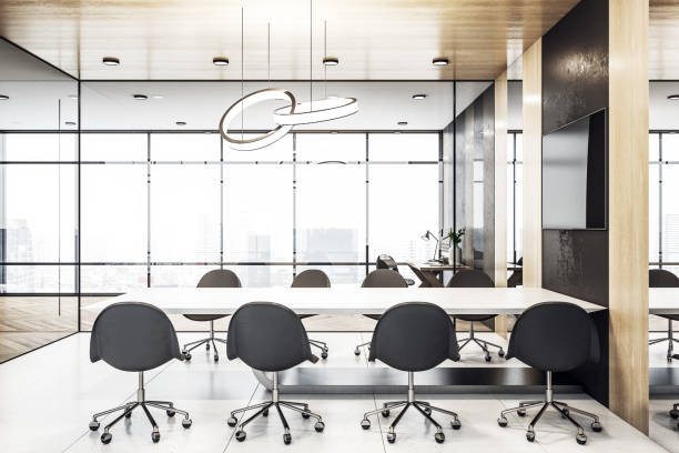 istock Modern spacious meeting room with light table, dark chairs and big windows with great city view 1304086480