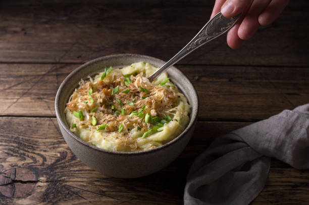 istock Traditional Irish dish colcannon, mashed potatoes with cabbage and green onions, on top of crispy fried cabbage topping with nuts and spices on a wooden table 1304087937