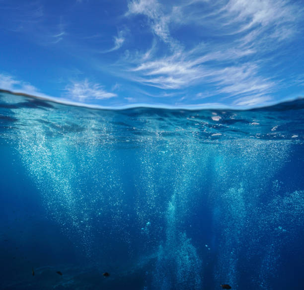 Air bubbles underwater and sky over under water Seascape, air bubbles underwater sea and blue sky with cloud, split view over and under water surface, Mediterranean, France underwater stock pictures, royalty-free photos & images