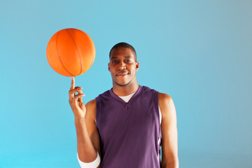 Basketball player balancing ball on one finger