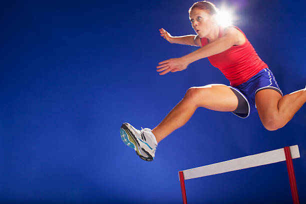 sportler springen über hürden - hürdenlauf laufdisziplin stock-fotos und bilder