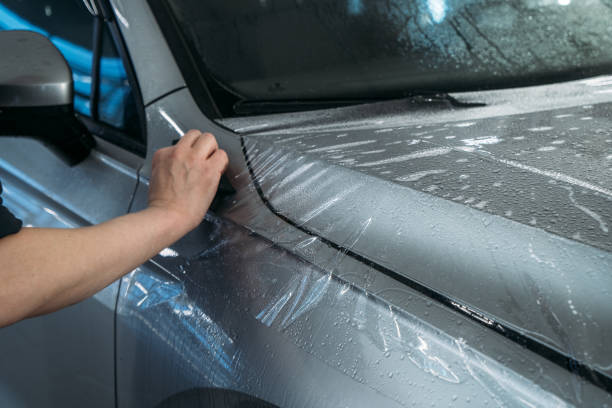 Process of Installing PPF or Paint Protection Film on car. Protective polymer skin for car Process of Installing PPF or Paint Protection Film on car. Protective polymer skin for car. vehicle wrap stock pictures, royalty-free photos & images