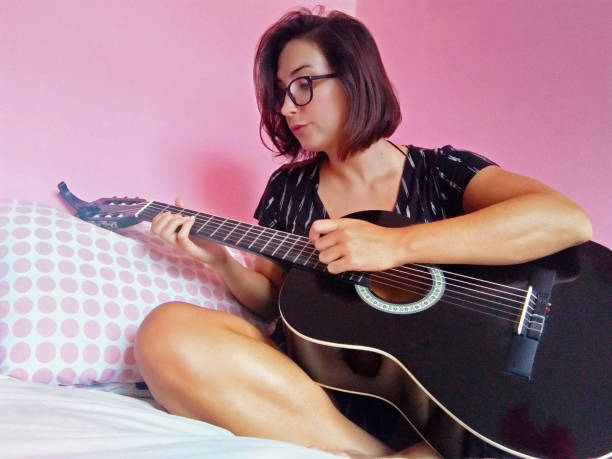 istock Girl singing and playing the guitar 1304094355