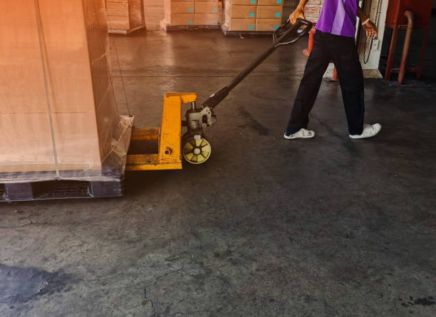 Worker driving forklift loading shipment carton boxes goods on wooden pallet at loading dock from container truck to warehouse cargo storage in freight logistics, transportation industrial, delivery trabajador que conduce carretillas elevadoras cargando cartones de carga mercancías en palet de madera en el muelle de carga desde camión contenedor hasta almacenamiento de carga de almacén en logística de carga, transporte industrial, entrega