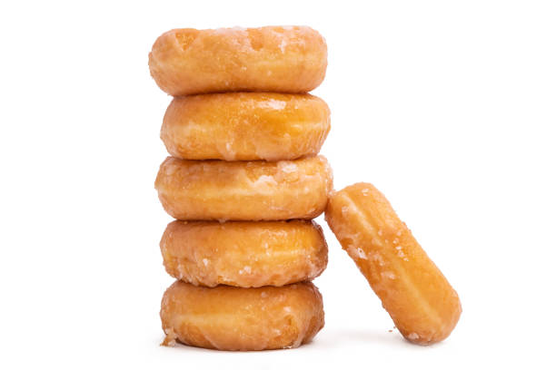 пончики с сахарной пудрой, уложенные на белом фоне - donut shape стоковые фото и изображения