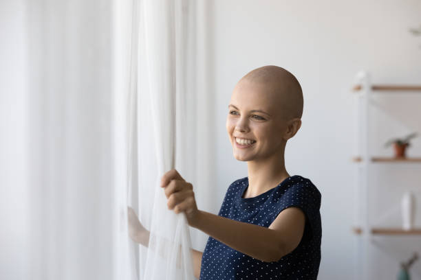 istock Happy bald cancer patient open curtains feeling good 1304099307