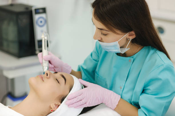 Professional female cosmetologist doing Hydradermabrasian procedure in Cosmetology clinic. Doctor use hydra vacuum cleaner. Rejuvenation And Hydratation. Cosmetology stock photo