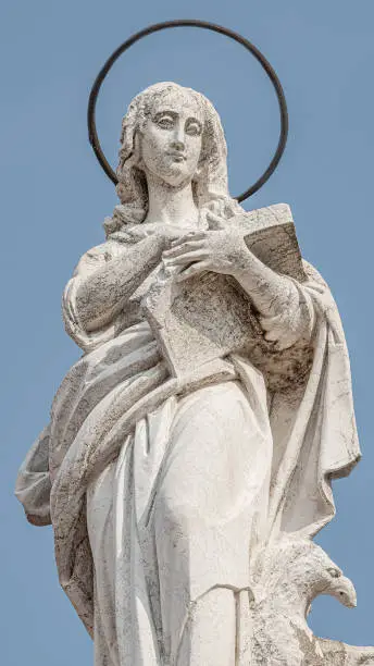 Photo of Ancient aged sculpture of beautiful Holy Maria at roof of Santa Maria Assunta Jesuits Church in Venice, Italy, details, closeup
