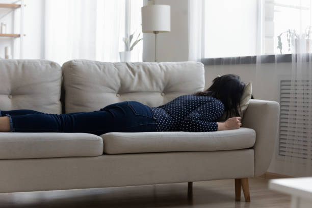 istock Exhausted millennial asian korean woman sleeping on sofa. 1304102561