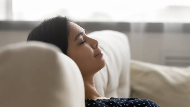 istock Happy serene millennial asian woman sleeping on sofa. 1304102611