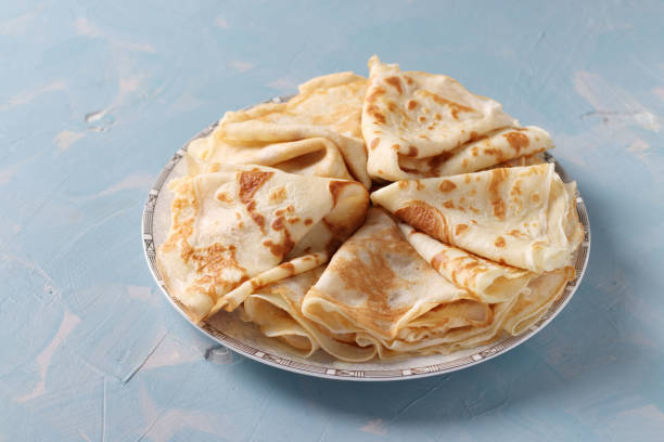 istock Thin pancakes with wheat flour, eggs and milk on light blue background 1304104556